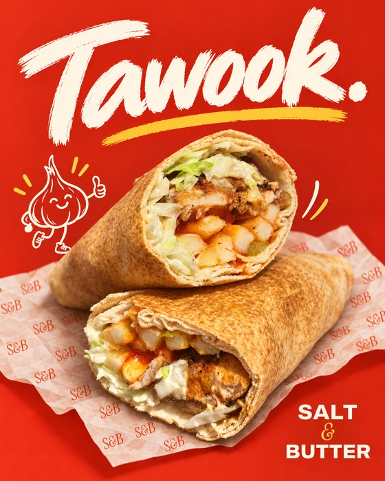 Toasted Tawook sandwich cut in two, with chicken, coleslaw and fries